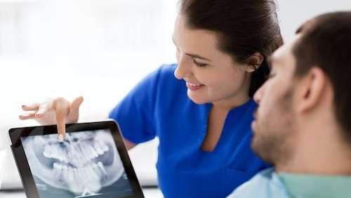 Female dentist in Rehoboth DE showing dental X-ray of her patient