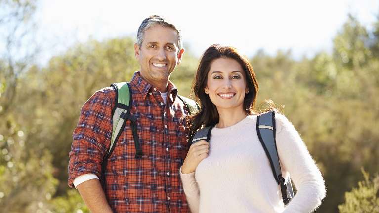 Couple with front dental implants hiking at Rehoboth Beach