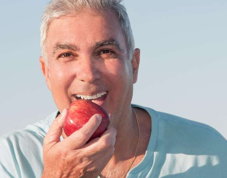eating apple confidently with dental implants Rehoboth Beach DE 