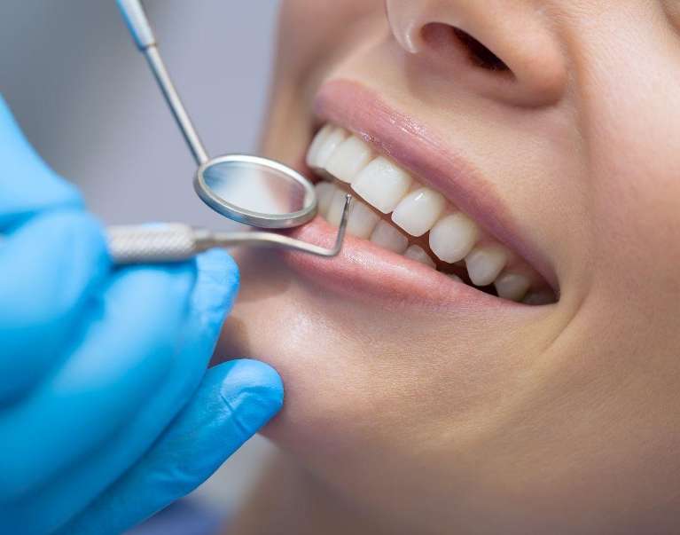 dentist examining dental patient's teeth in Rehoboth Beach, DE